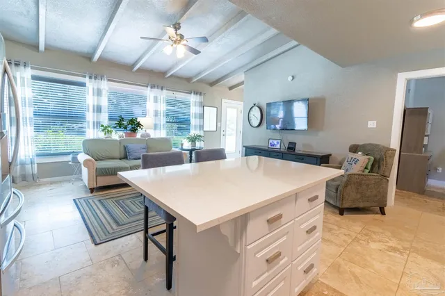 a living room with furniture a large window and a chandelier