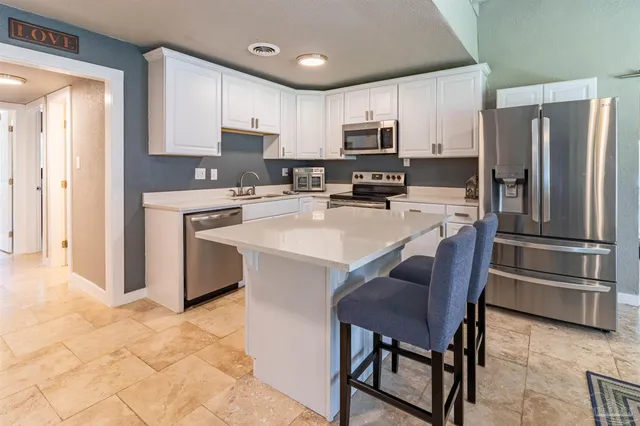 a kitchen with stainless steel appliances a refrigerator stove microwave and sink