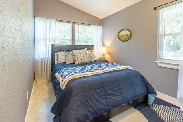 a bed sitting in a bedroom next to a window