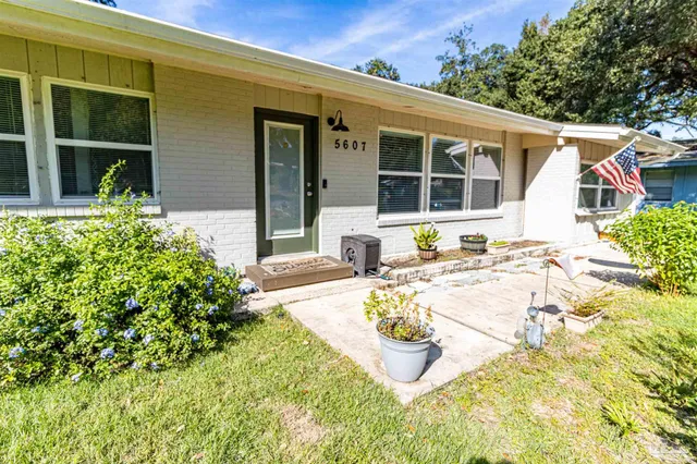 a view of a house with backyard and sitting area