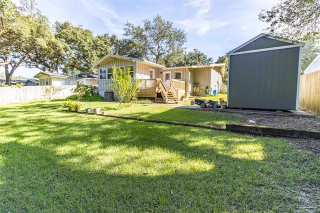 a view of a house with a big yard and a large tree