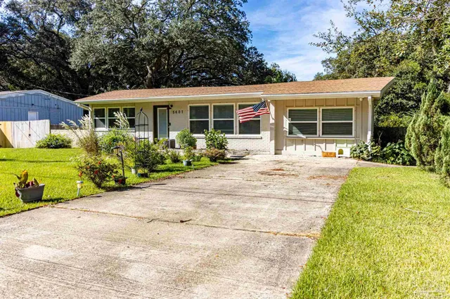 a front view of a house with a yard and potted plants