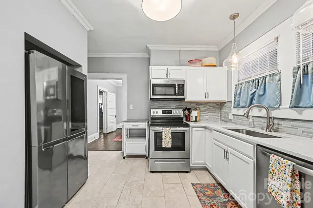 a kitchen with kitchen island granite countertop a sink appliances cabinets and counter space