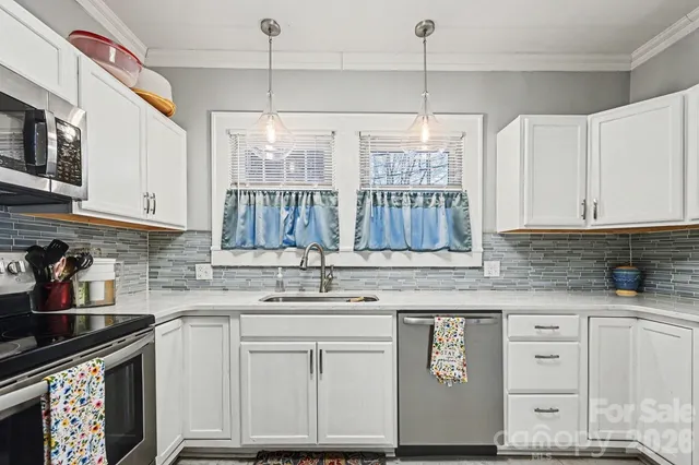 a kitchen with granite countertop a sink window and cabinets