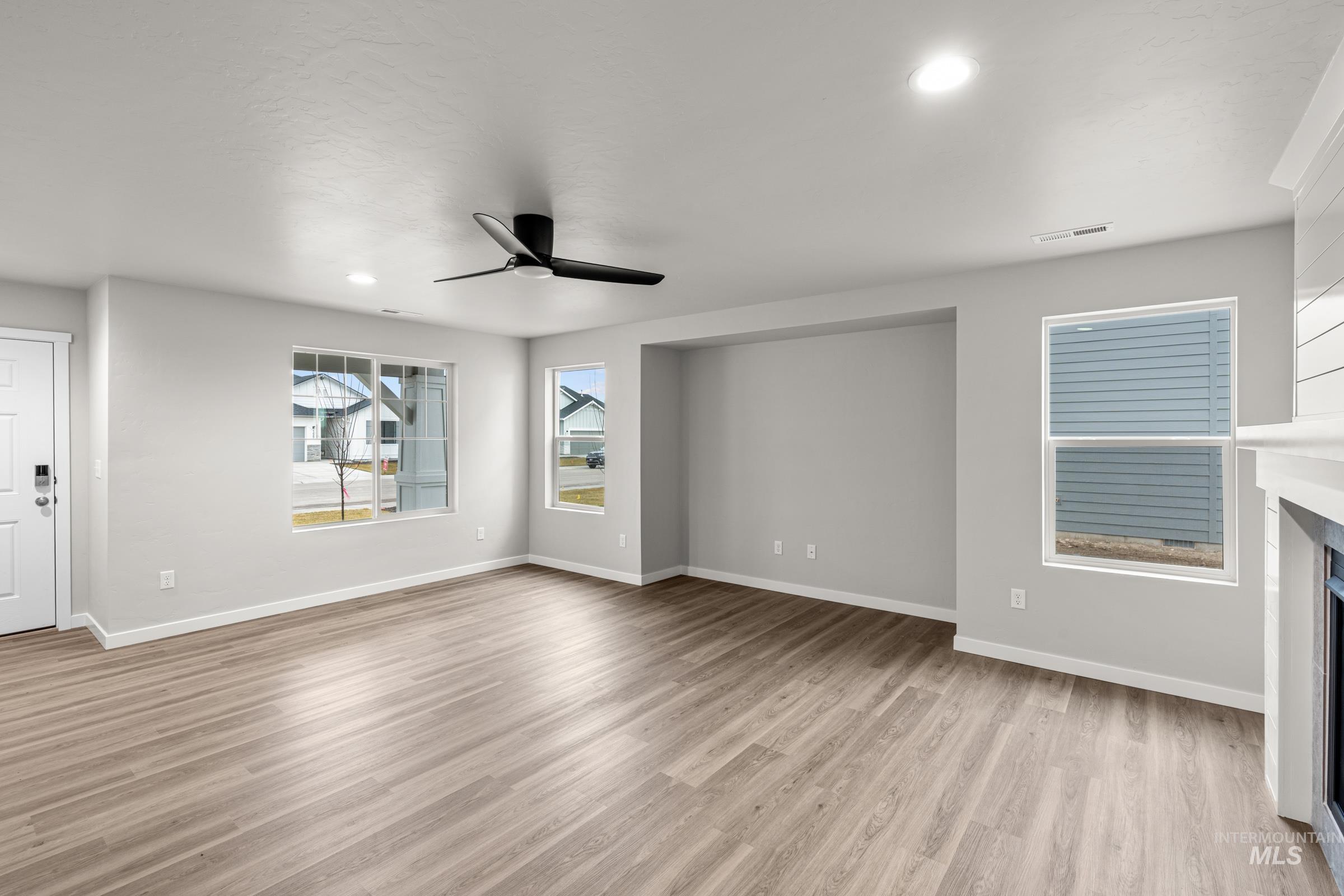 1651 Dyer Street Middleton, ID 83644 - Photo 11 of 28 Unfurnished living room featuring a fireplace, light wood-style flooring, ceiling fan, and recessed lighting
