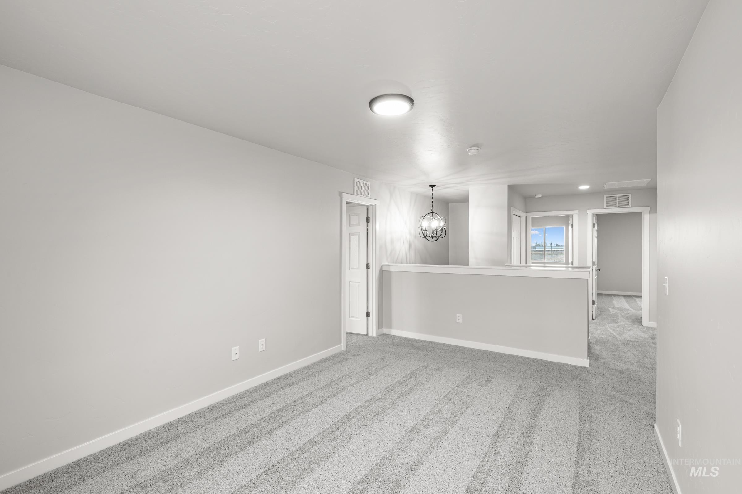 1651 Dyer Street Middleton, ID 83644 - Photo 15 of 28 Empty room featuring light carpet and a chandelier