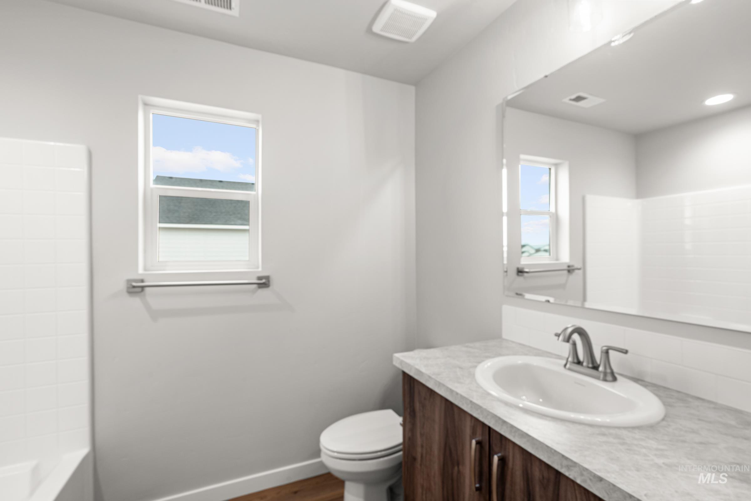 1651 Dyer Street Middleton, ID 83644 - Photo 27 of 28 Full bath featuring vanity, dark wood-type flooring, healthy amount of natural light, and shower / bathtub combination