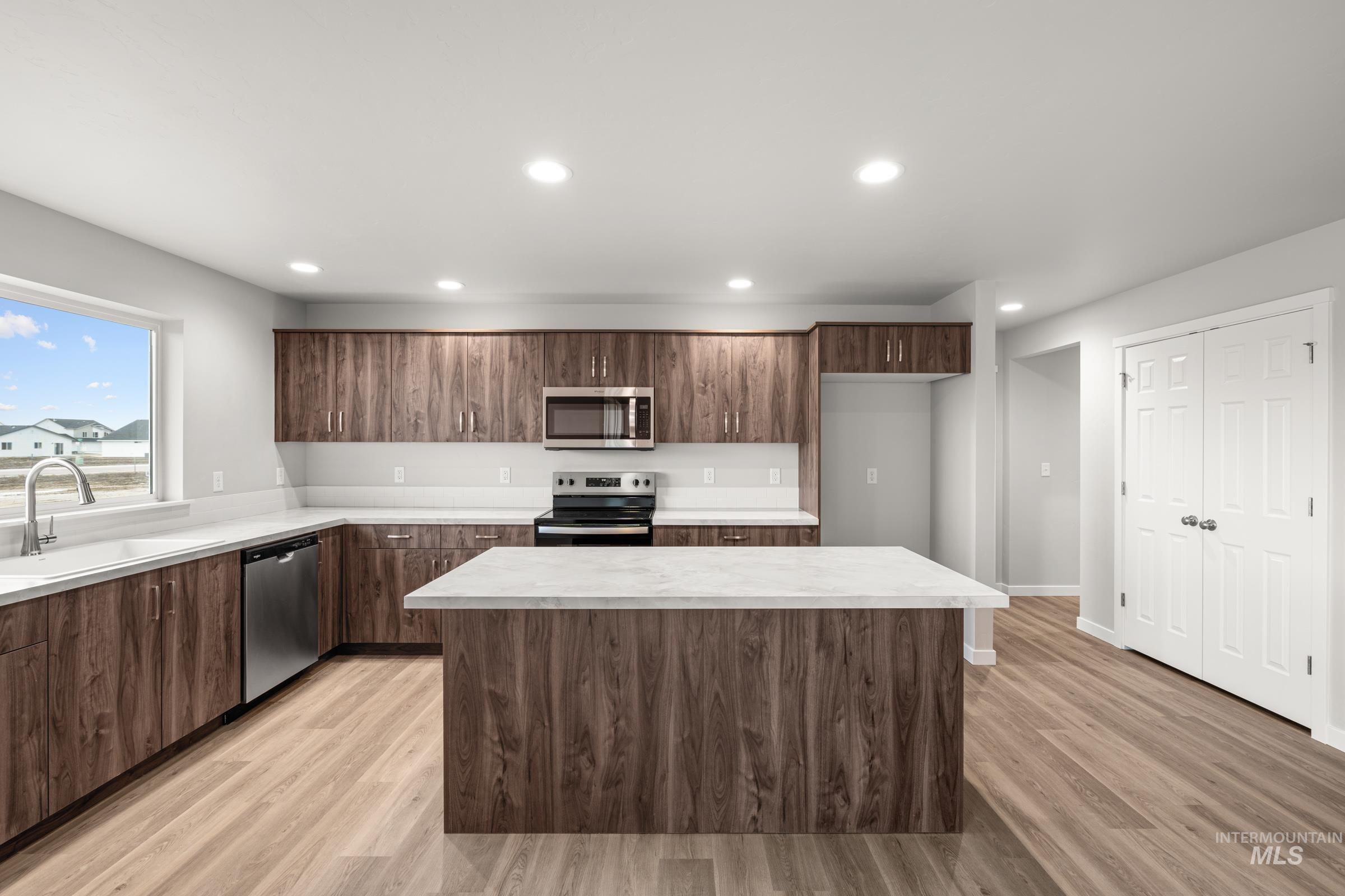1651 Dyer Street Middleton, ID 83644 - Photo 3 of 28 Kitchen featuring light countertops, stainless steel appliances, modern cabinets, light wood-style flooring, and a kitchen island