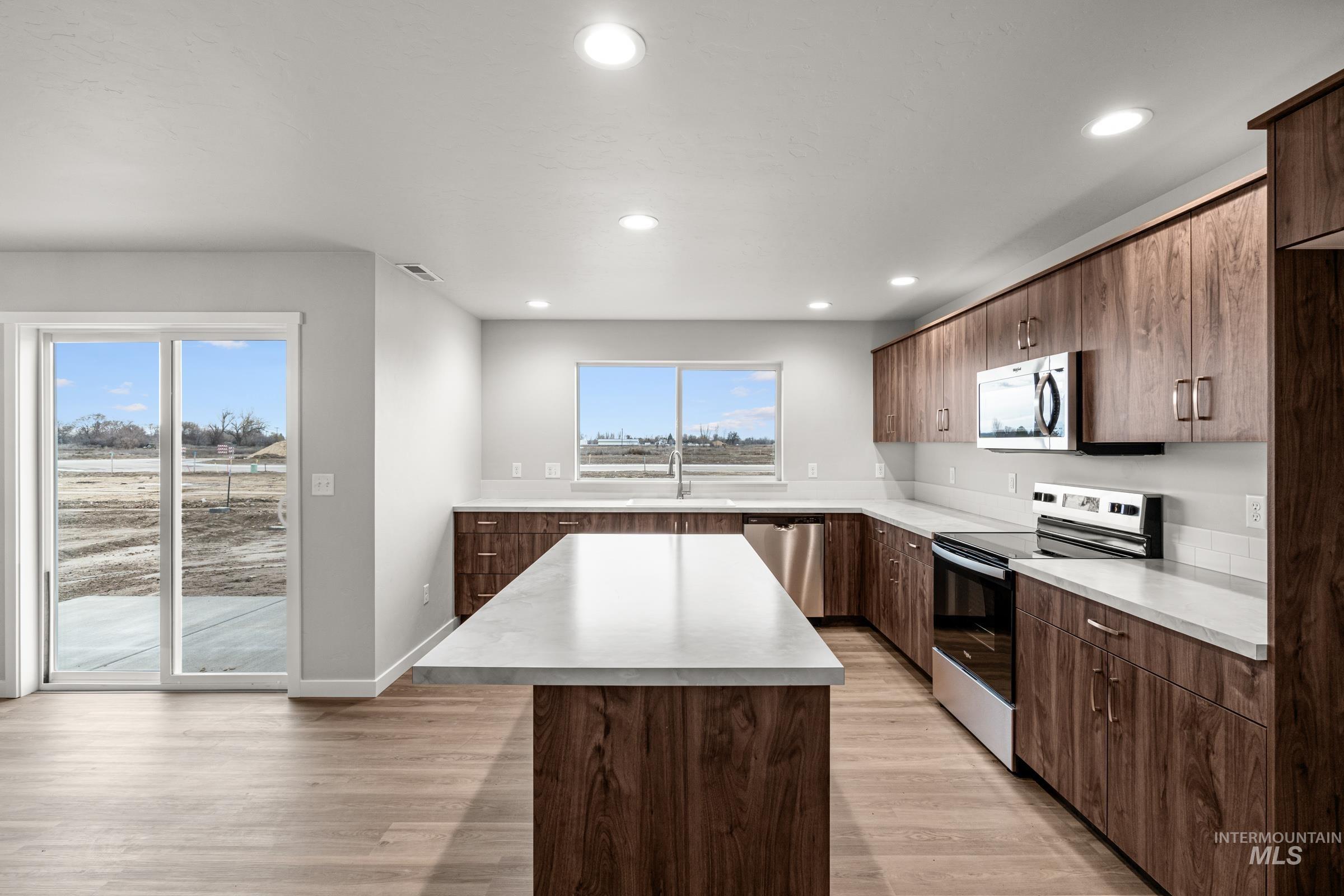 1651 Dyer Street Middleton, ID 83644 - Photo 4 of 28 Kitchen with stainless steel appliances, light countertops, a kitchen island, light wood-style floors, and recessed lighting