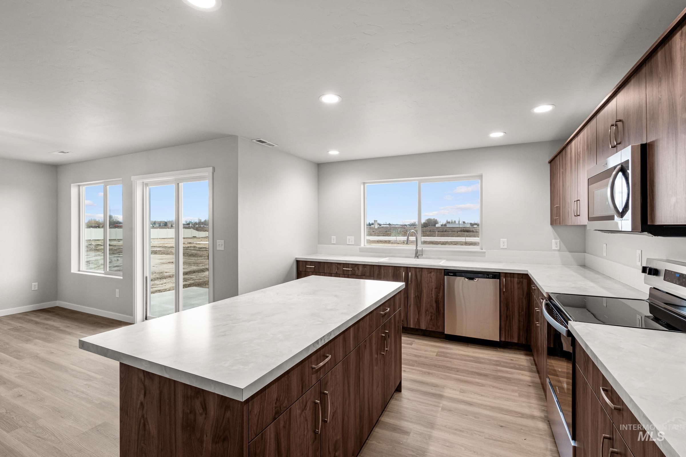 1651 Dyer Street Middleton, ID 83644 - Photo 5 of 28 Kitchen with stainless steel appliances, dark wood finish cabinets, light wood-style flooring, light countertops, and recessed lighting