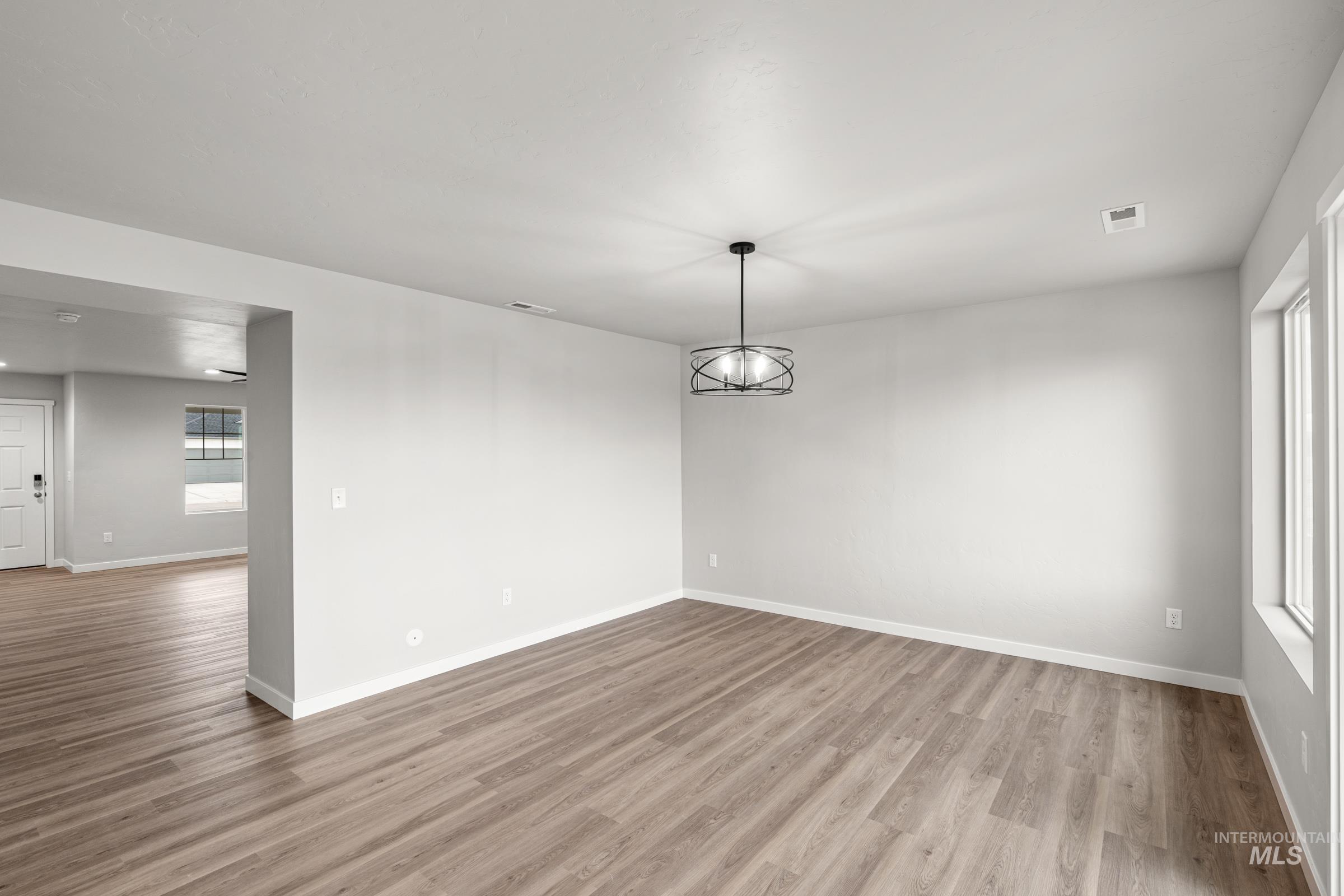 1651 Dyer Street Middleton, ID 83644 - Photo 6 of 28 Spare room with wood finished floors and a chandelier