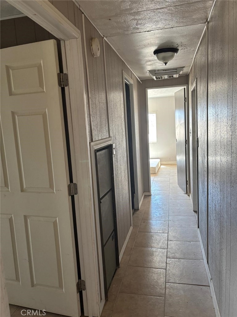 11690 Camp Rock Road Lucerne Valley, CA 92356 - Photo 28 of 33 a view of hallway with stainless steel appliances wooden floor and staircase