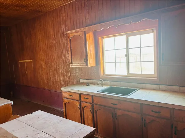 a large kitchen with stainless steel appliances granite countertop a sink a stove and a refrigerator