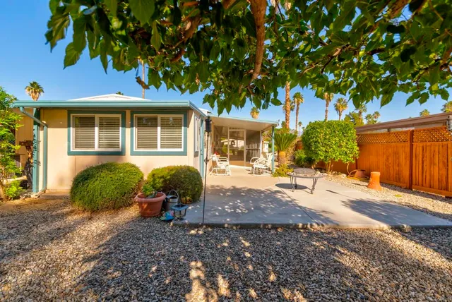 a view of a house with backyard and sitting area