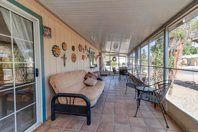 a dining room with furniture and a floor to ceiling window