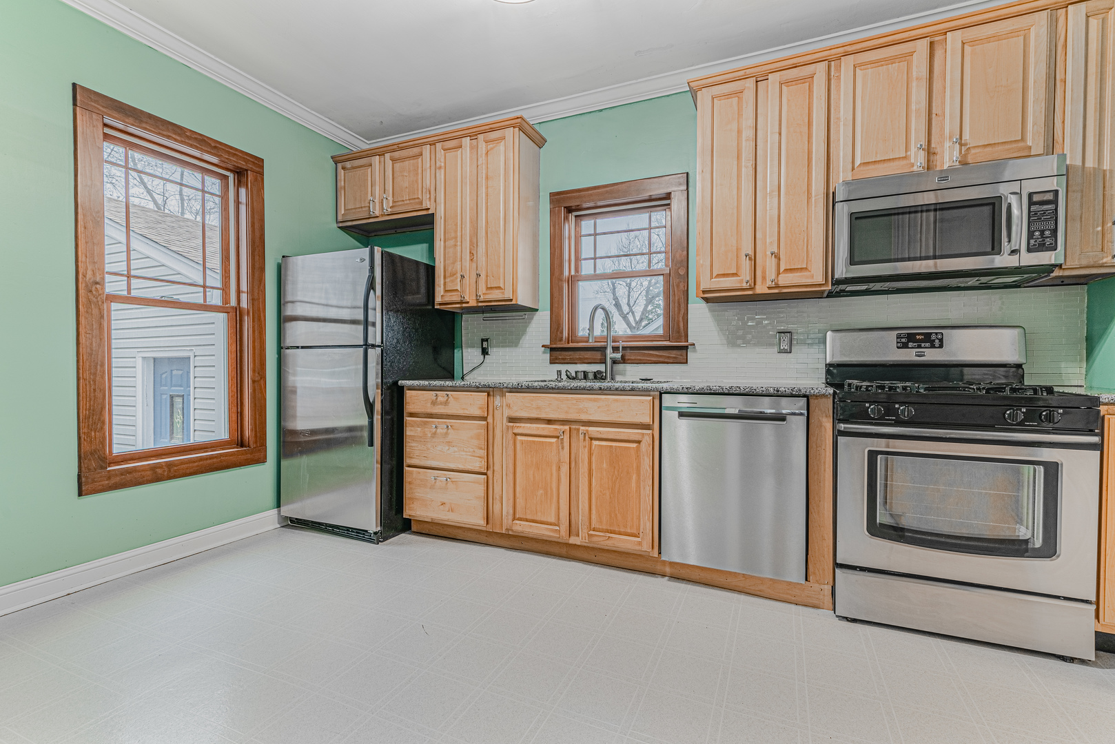 1507 Riverside Drive McHenry, IL 60050 - Photo 12 of 27 a kitchen with stainless steel appliances granite countertop white cabinets a microwave a sink and a window
