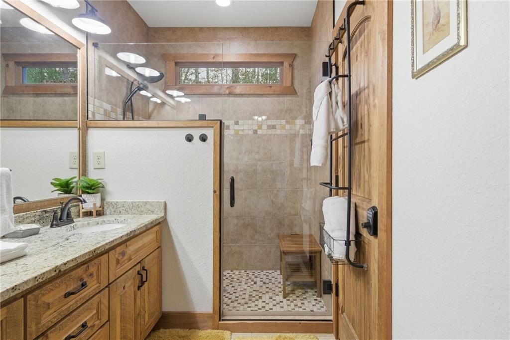 41 Bunks Way Morganton, GA 30560 - Photo 17 of 33 a bathroom with a granite countertop shower a sink and a mirror