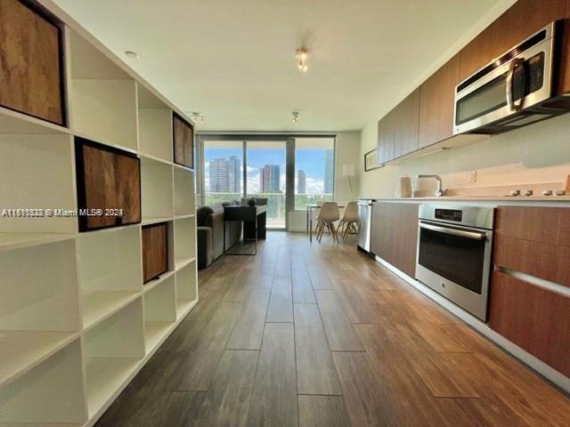 1600 Southwest 1st Avenue, Unit 511 Miami, FL 33129 - Photo 1 of 10 a kitchen with stainless steel appliances granite countertop a refrigerator a stove and a wooden floors