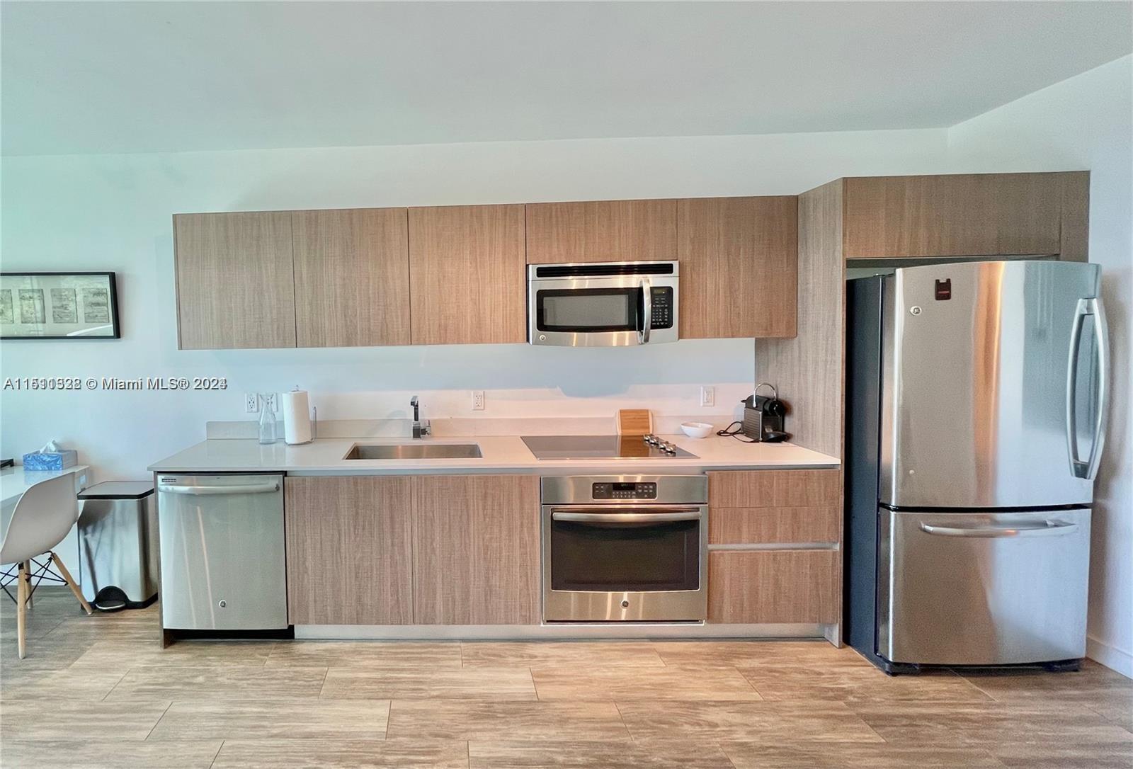 1600 Southwest 1st Avenue, Unit 511 Miami, FL 33129 - Photo 4 of 10 a kitchen with stainless steel appliances granite countertop a refrigerator stove a sink and a microwave