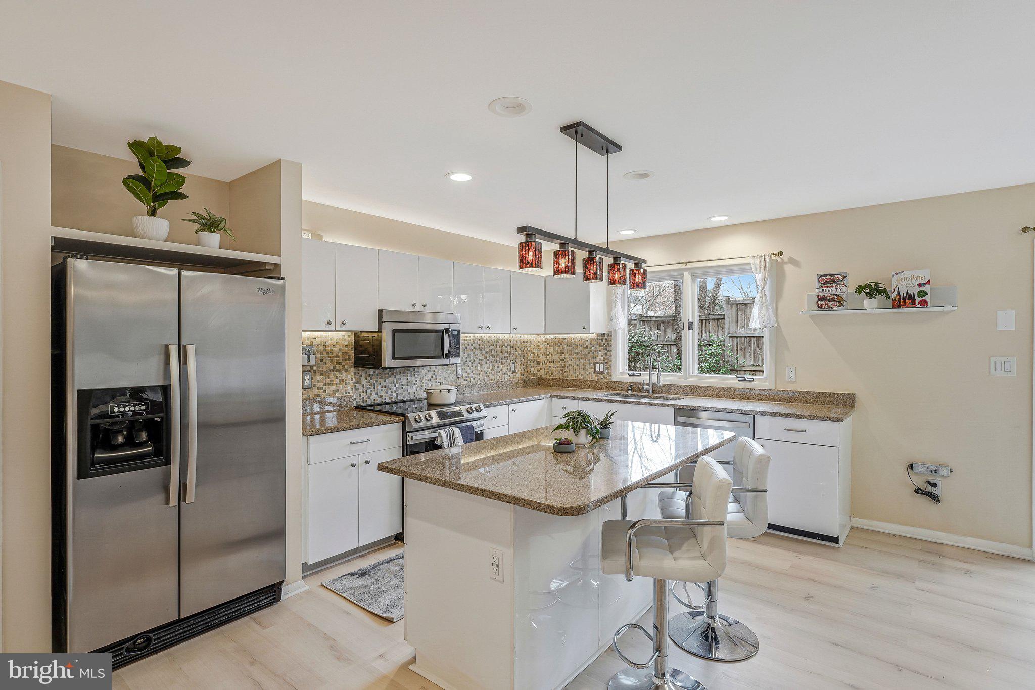 11123 Lakespray Way Reston, VA 20191 - Photo 3 of 47 a kitchen with stainless steel appliances granite countertop a sink a stove and a refrigerator