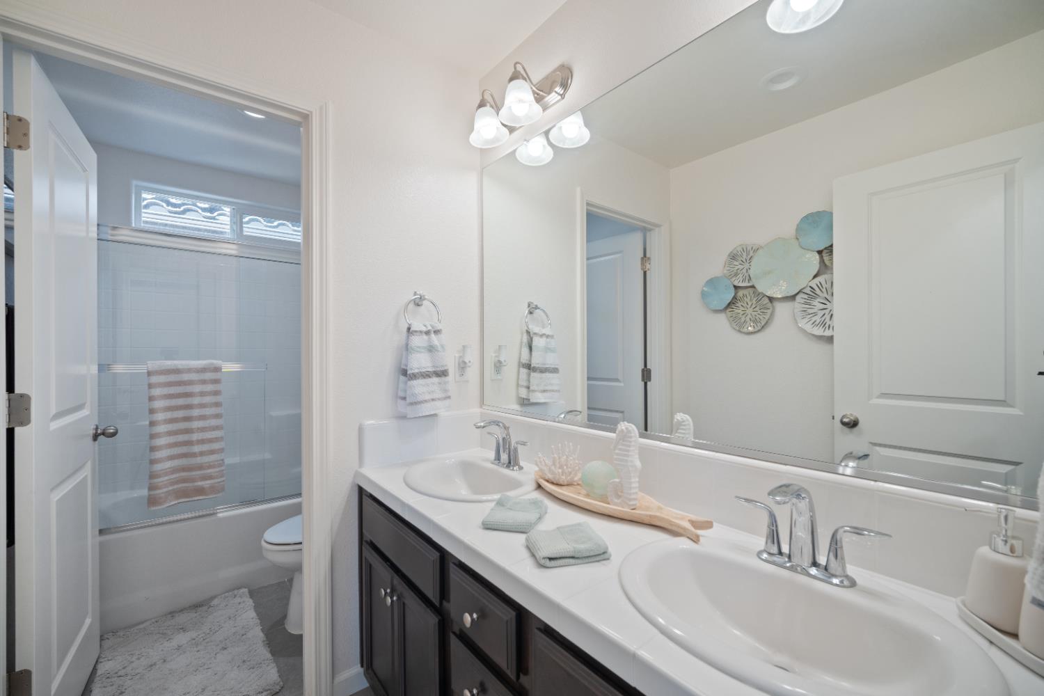 855 Wishon Avenue Madera, CA 93636 - Photo 19 of 29 a bathroom with a granite countertop sink a toilet and a mirror