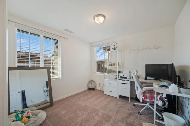 a view of a workspace with furniture and a window
