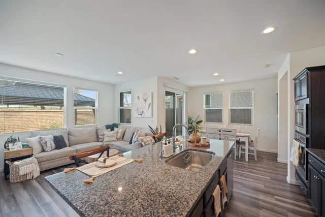 a living room with furniture wooden floor and a large window