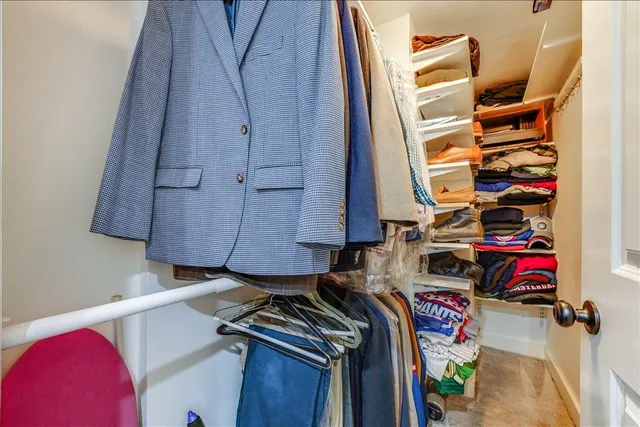 a view of walk in closet with clothes and shoes