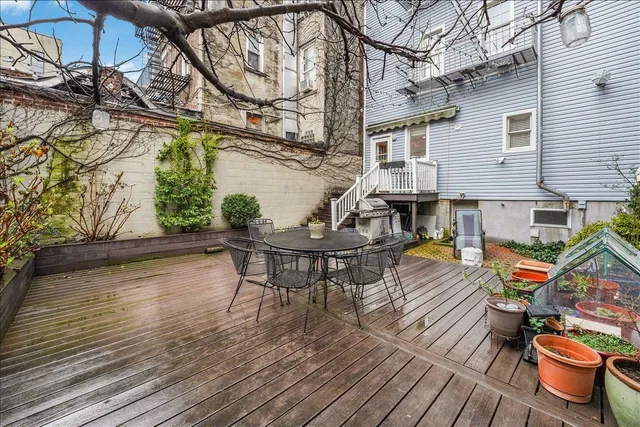 a view of a patio with table and chairs with wooden floor and fence