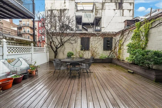 a roof deck view with table and chairs