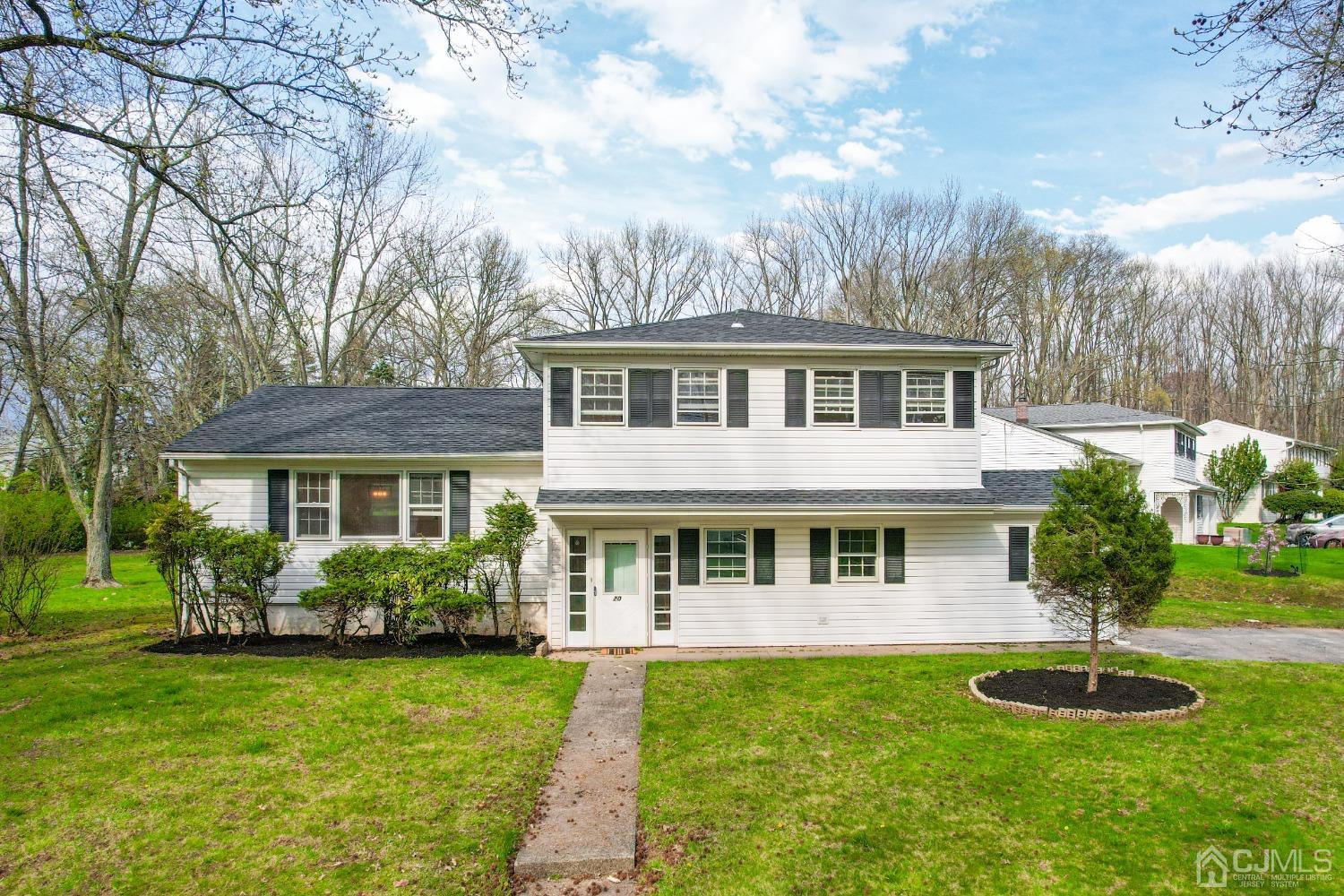 a front view of a house with a yard and trees