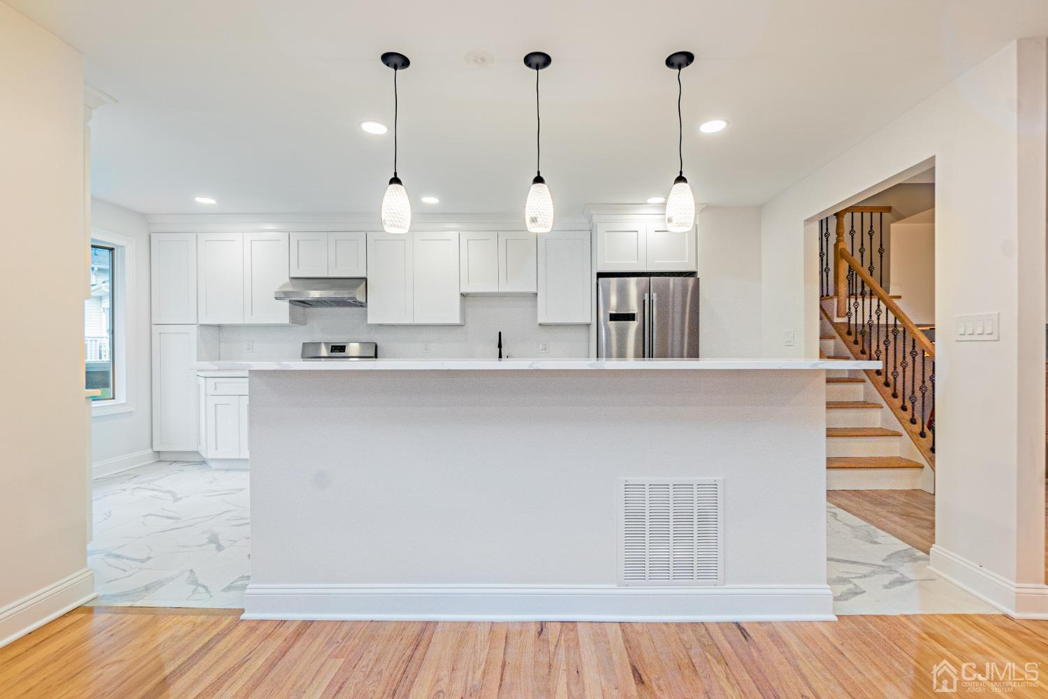 20 Warwick Road Edison, NJ 08820 - Photo 11 of 34 a large kitchen with kitchen island a stove a sink dishwasher and a wooden cabinets