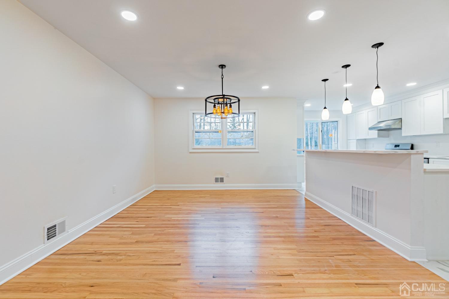 20 Warwick Road Edison, NJ 08820 - Photo 10 of 34 a view of an empty room and kitchen with wooden floor