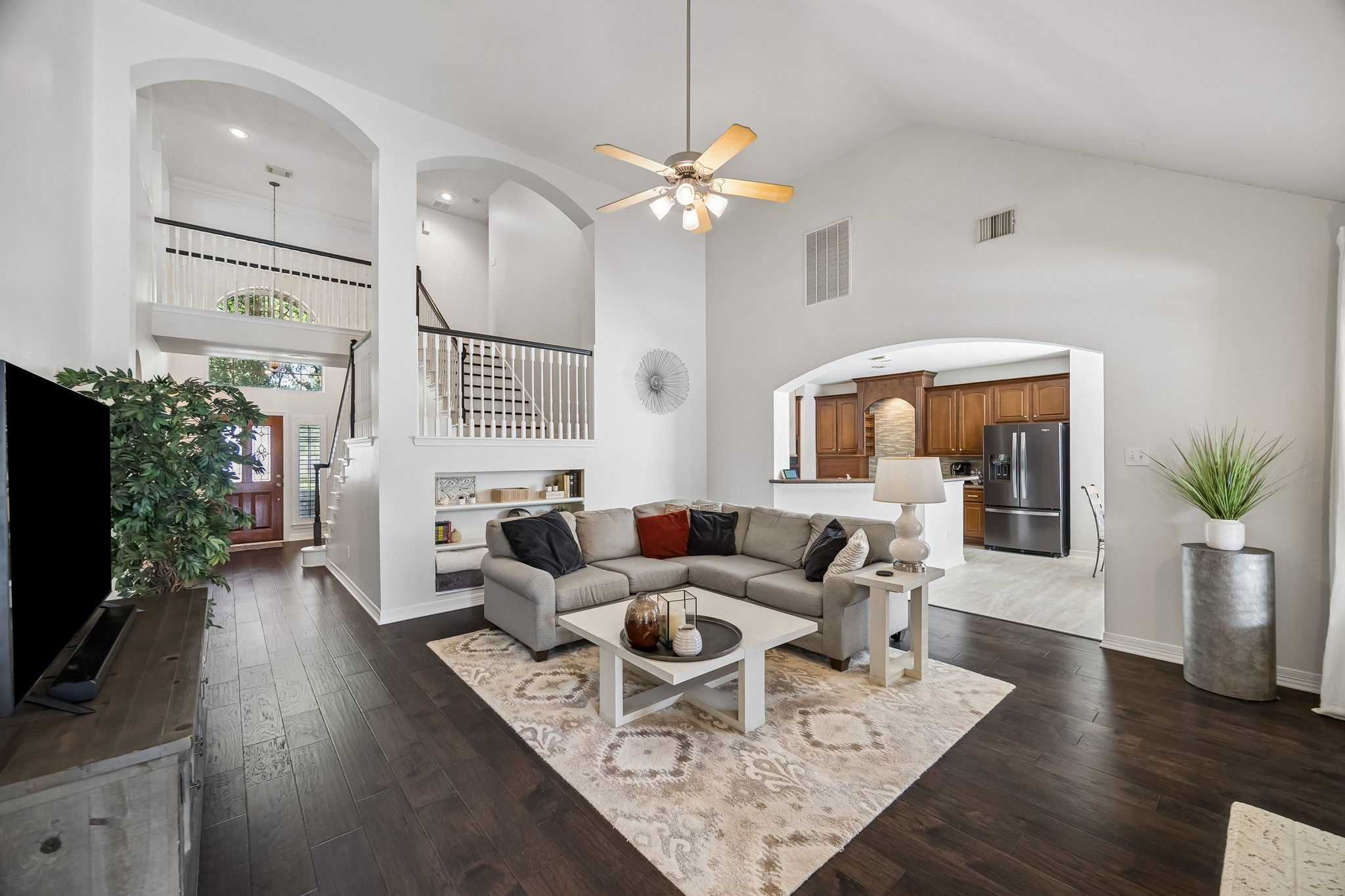 5718 Brennan Ridge Lane Katy, TX 77450 - Photo 3 of 42 SOARING CEILINGS & SEAMLESS FLOW: Rich hand-scraped wood floors, dramatic ceilings, and an open-concept layout create an inviting gathering space that connects effortlessly to the kitchen and beyond.