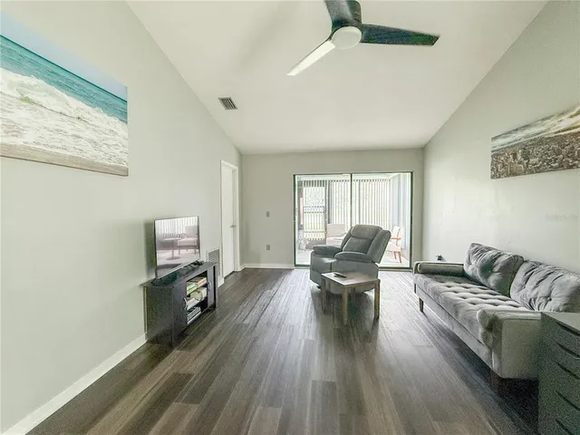a living room with furniture and a wooden floor