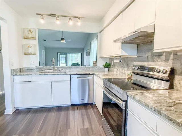 a kitchen with stainless steel appliances granite countertop a sink and stove top oven