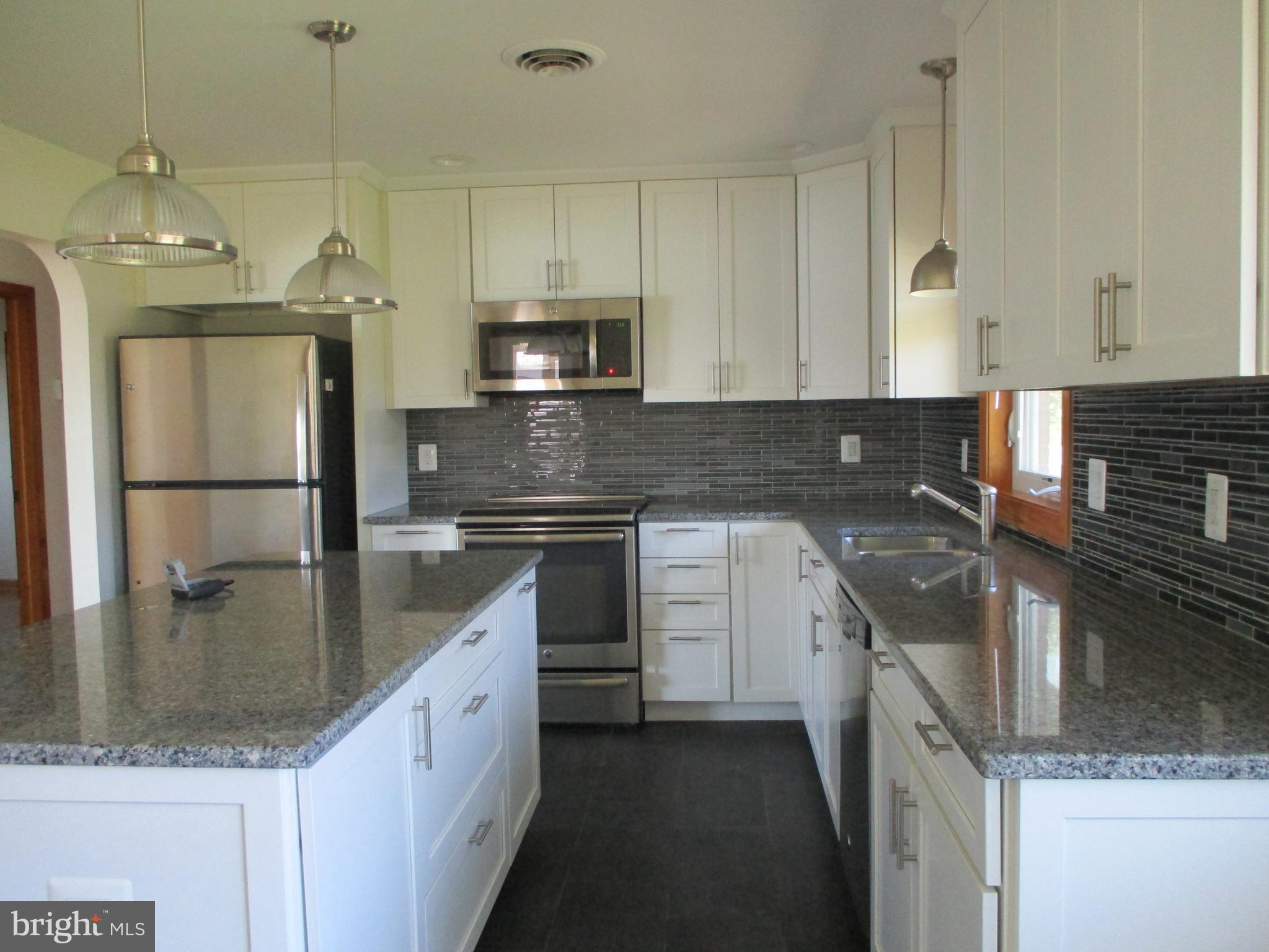 24244 Half Pone Point Road Hollywood, MD 20636 - Photo 3 of 19 a kitchen with stainless steel appliances granite countertop a sink a stove and a refrigerator