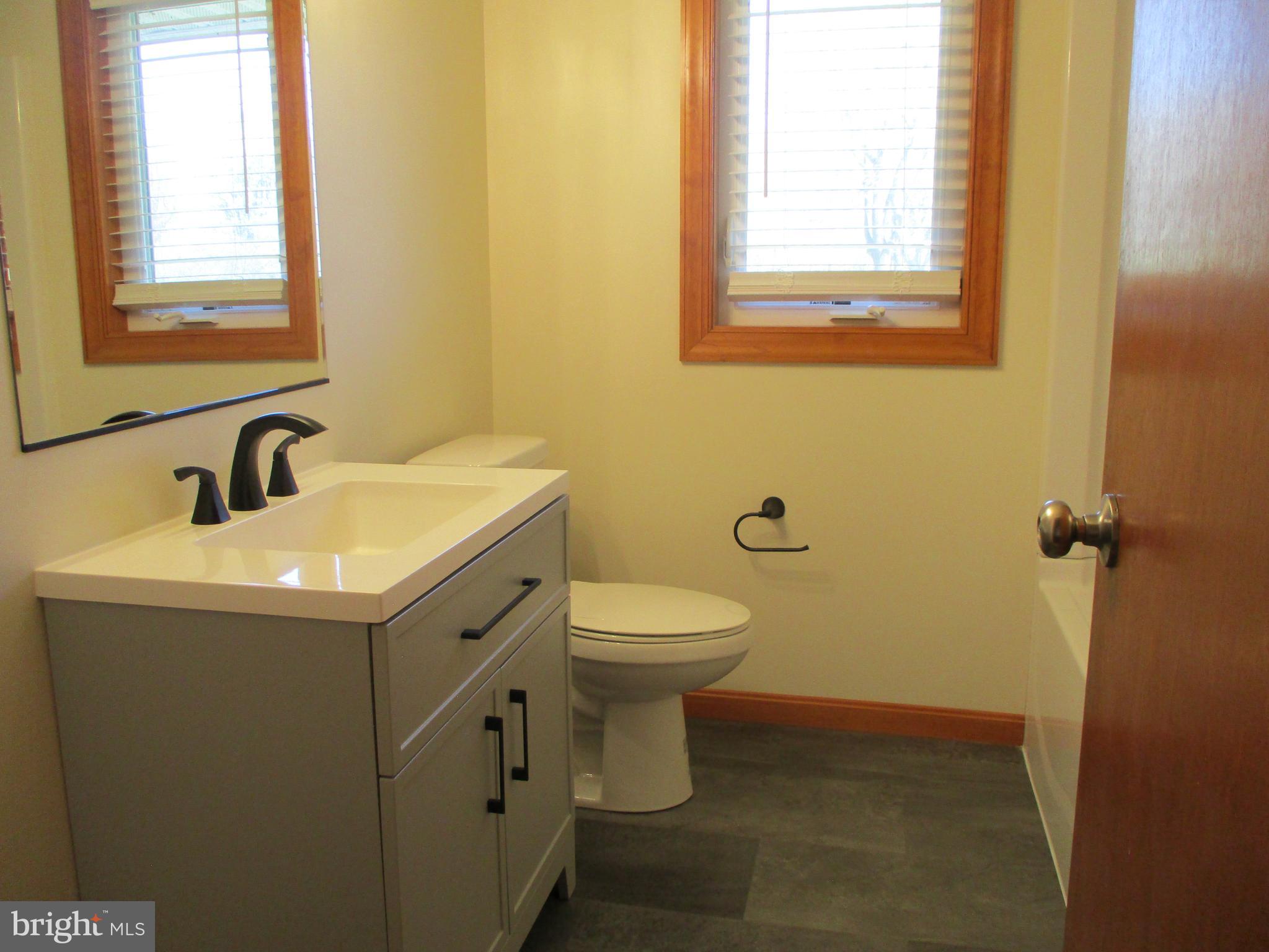 24244 Half Pone Point Road Hollywood, MD 20636 - Photo 5 of 19 a bathroom with a toilet sink and mirror