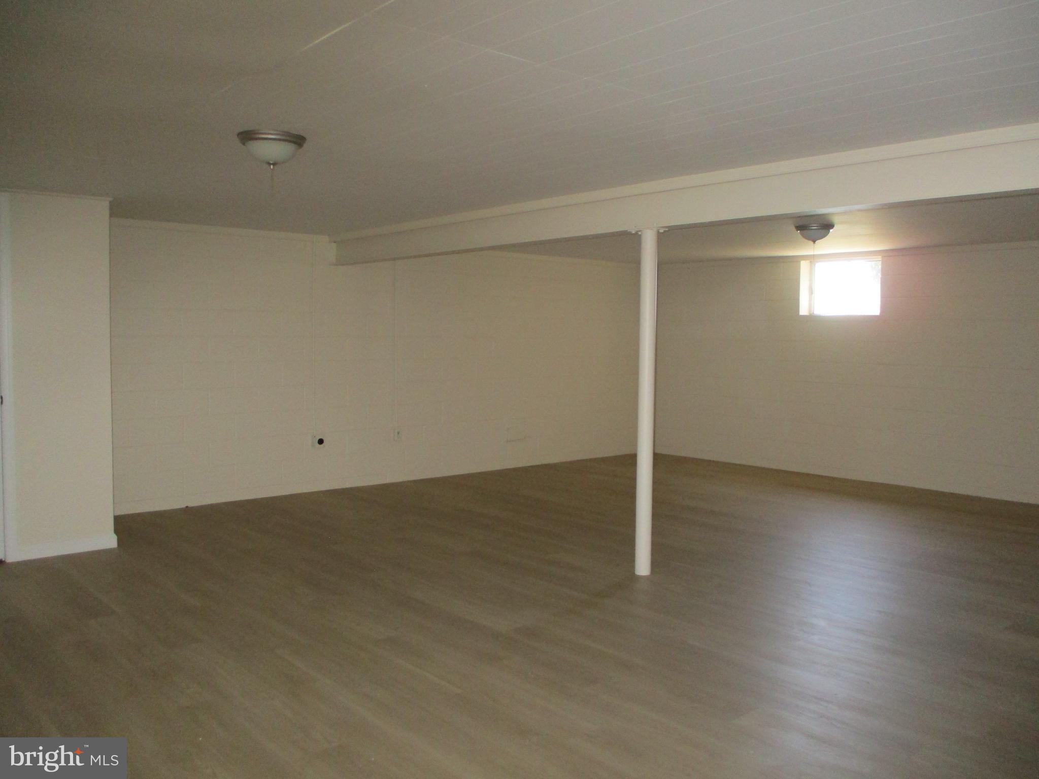 24244 Half Pone Point Road Hollywood, MD 20636 - Photo 8 of 19 an empty room with wooden floor and windows