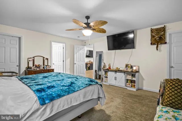 a spacious bedroom with a bed and a flat screen tv