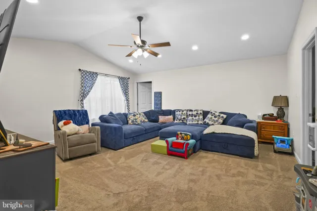 a living room with furniture a ceiling fan and a window