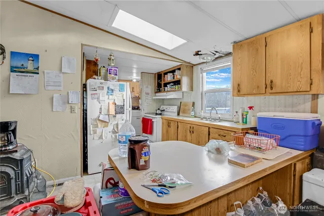 a living room with stainless steel appliances furniture a rug and a window