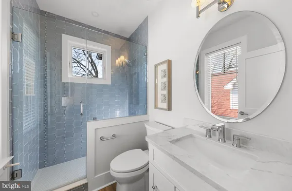 a bathroom with a toilet a sink and mirror