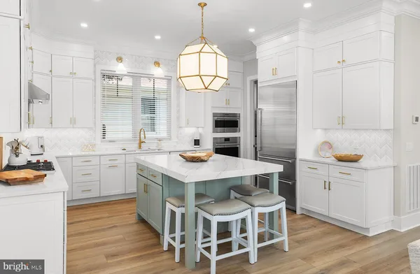 a kitchen with granite countertop white cabinets and refrigerator