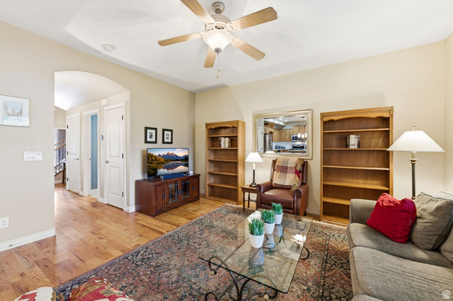7235 Viansa Court Midvale, UT 84047 - Photo 6 of 43 Living room with arched walkways, light wood finished floors, and ceiling fan