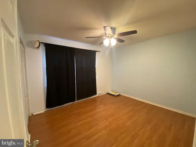 an empty room with closet and a chandelier fan