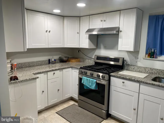 a kitchen with granite countertop white cabinets and stainless steel appliances