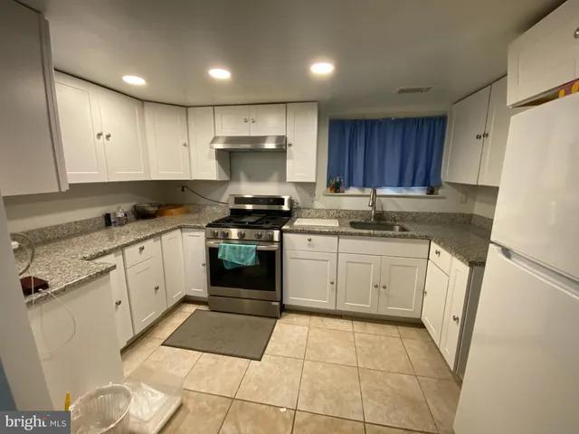 a kitchen with a sink a stove and cabinets