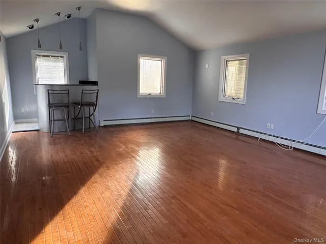 a view of a room with wooden floor and a window