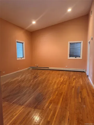 a view of an empty room with wooden floor